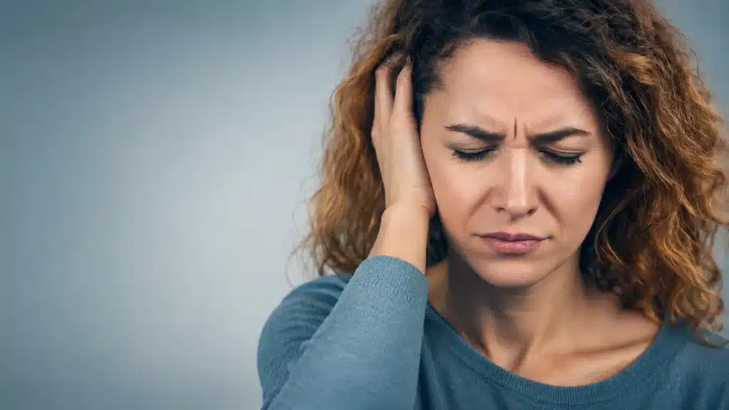 traumafolgen-im-koerper-julia-belke Frau mit Stresssymptomen und innerer Anspannung – Traumafolgen im Körper und Nervensystem.